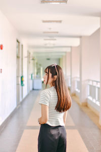 Full length of woman wearing sunglasses standing in building