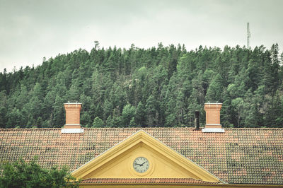 Built structure by trees against sky in forest