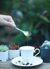 Midsection of person holding coffee cup on table