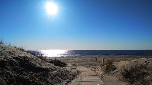 Scenic view of beach against clear blue sky