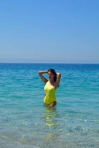 Young woman in sea against clear sky