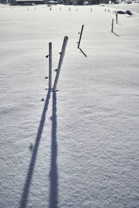 High angle view of wooden post on snow covered field