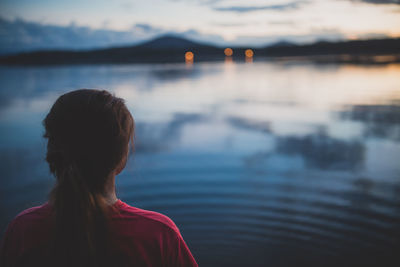 Woman looking at lake during sunset