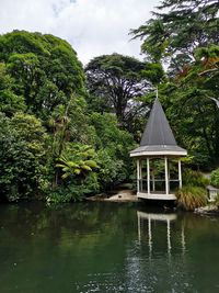 Gazebo by lake against sky