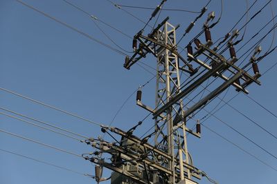 Low angle view of electricity pylon against sky