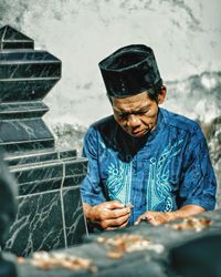 Man working with food sitting outdoors