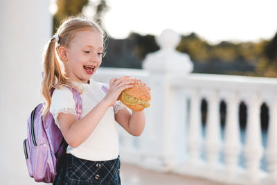 Smiling cute girl holding hamburger