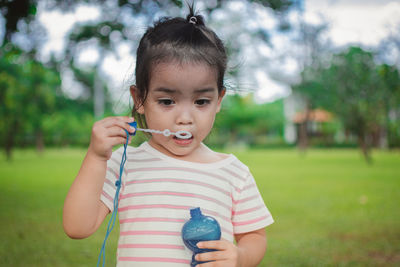 Girl holding bubble wand at park