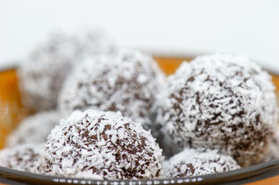 Coconut dessert balls in front of white background