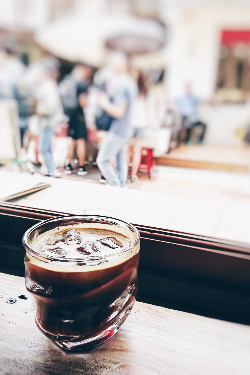 table, drink, food and drink, focus on foreground, refreshment, coffee - drink, coffee, still life, close-up, indoors, incidental people, wood - material, drinking glass, freshness, cup, day, glass, household equipment, iced coffee, brown, latte, non-alcoholic beverage