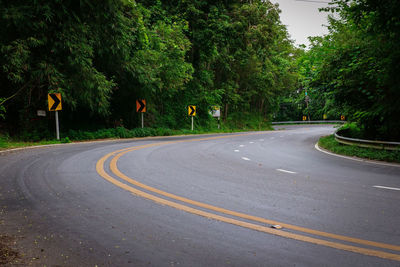 Road amidst trees and plants in city