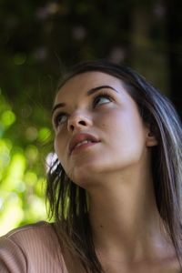 Low angle view of teenage girl looking away 