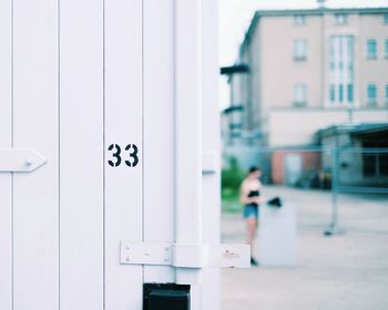 Close-up of number 33 on white wooden door