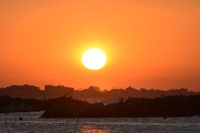 Scenic view of sea against orange sky