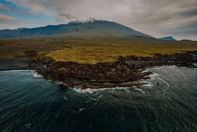 Scenic view of sea and mountains against sky