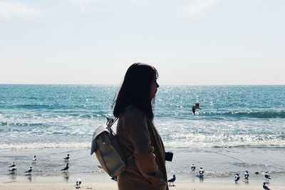 Woman at beach against sky