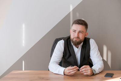 Portrait bearded business man sitting in office meditating holding pen in his