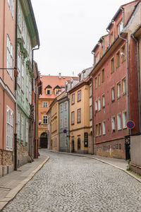 Alley amidst buildings against clear sky