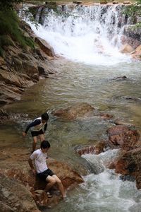 Two children playing in rockpool at waterfall