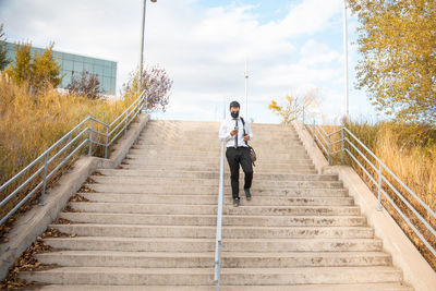 Rear view of man on staircase against sky