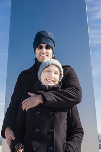 Portrait of smiling couple standing against sky