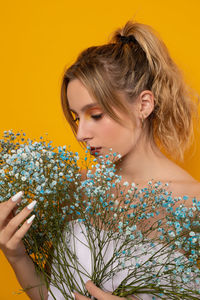 Portrait of beautiful woman holding yellow flower