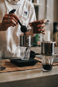 Man holding coffee cup on table