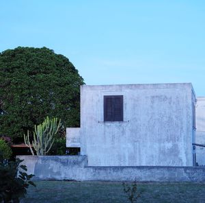 Building by lake against clear blue sky