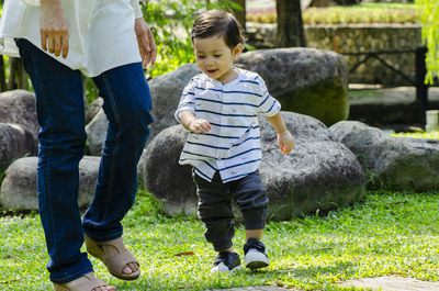 Rear view of boys standing on grass