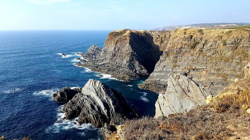 Rock formations by sea against sky