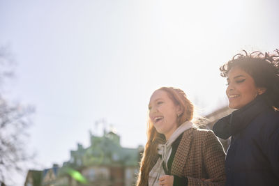 Female friends walking together ourdoors on walkway in city