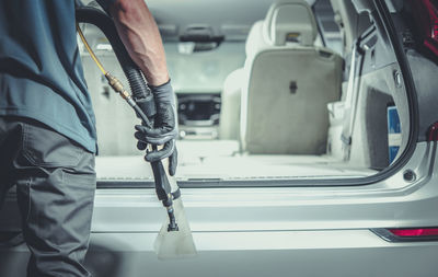 Midsection of man cleaning car