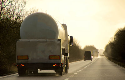 Vehicles on road against sky in city