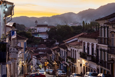 Buildings in city against sky during sunset