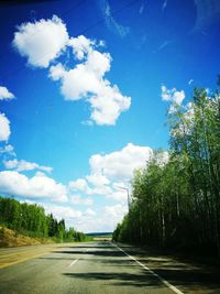 Road amidst trees against sky