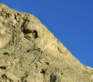 Low angle view of mountain against clear blue sky