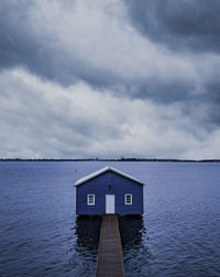Built structure by sea against sky