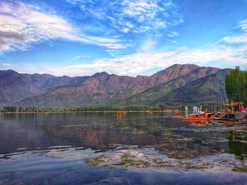 Scenic view of lake by mountains against sky