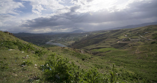 Scenic view of valley and mountains against sky