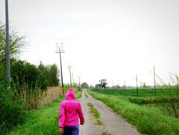Rear view of woman walking on field