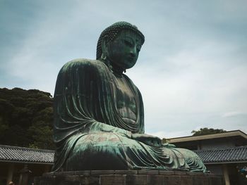 Low angle view of statue against cloudy sky