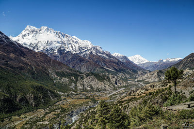 Scenic view of snowcapped mountains against clear sky