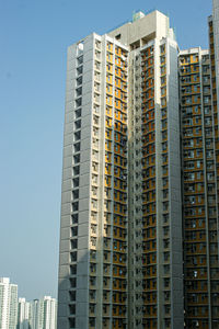 Low angle view of modern buildings against blue sky