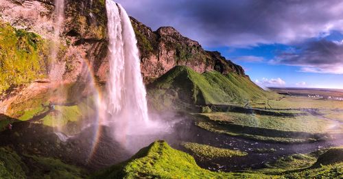 Scenic view of waterfall against sky