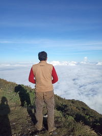 Rear view of man standing against sky