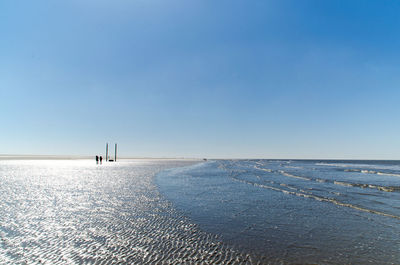 Scenic view of beach against clear blue sky