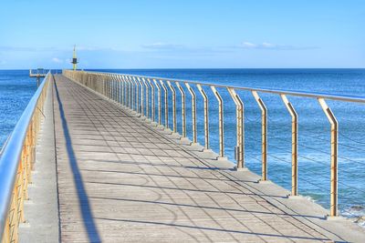 Pier over sea against blue sky