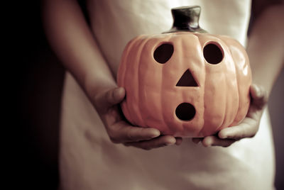 Close-up of woman hand holding jack o lantern during halloween