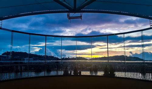 Bridge over river against sky during sunset