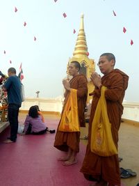 People standing outside temple against clear sky